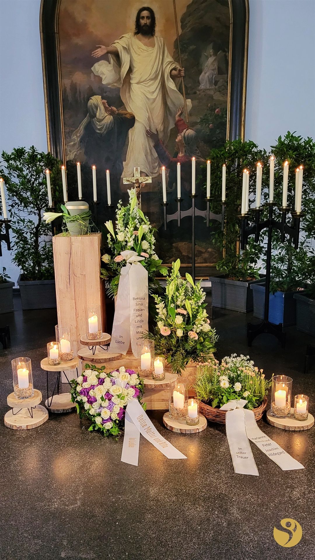 Urne mit floralem Schmuck und Kerzen